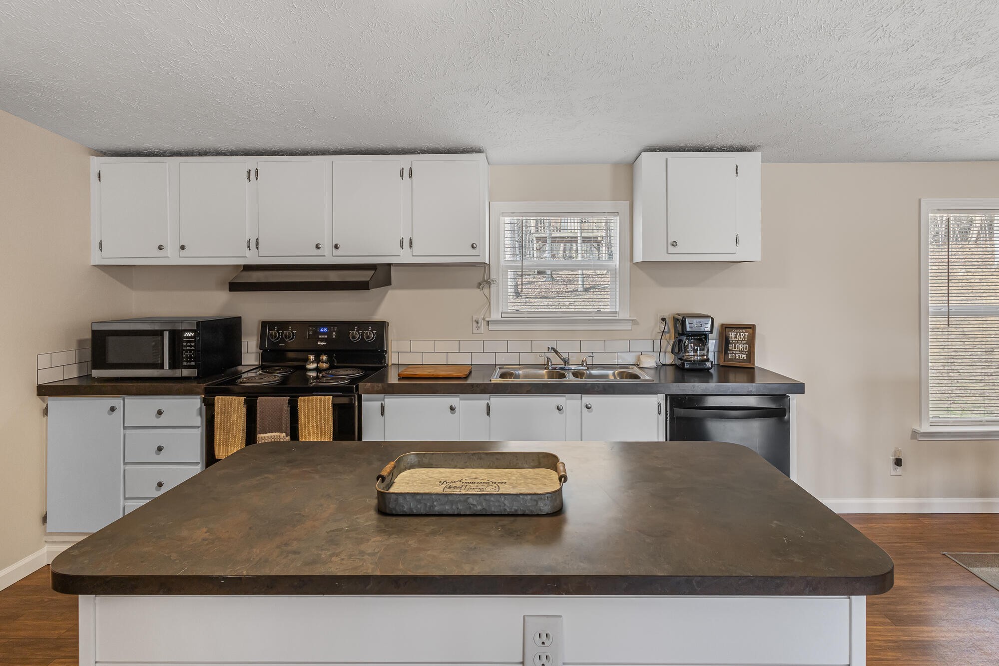 185 Bivens Road Tellico Plains, TN 37385 - Photo 18 of 34 a kitchen with kitchen island granite countertop a sink a stove and white cabinets