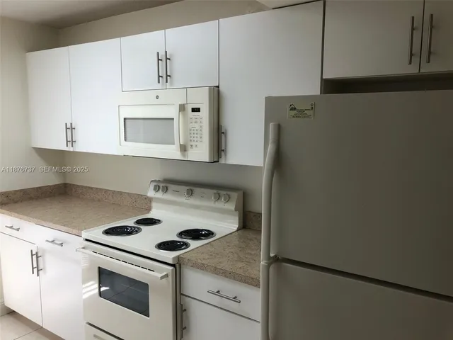 a white stove top oven sitting inside of a kitchen