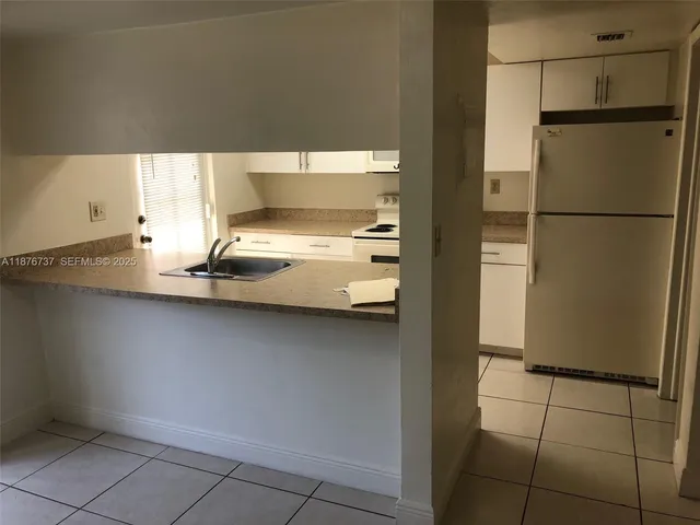 a kitchen with a refrigerator and window