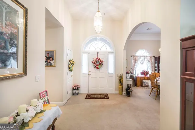 a living room with furniture a fireplace and a chandelier