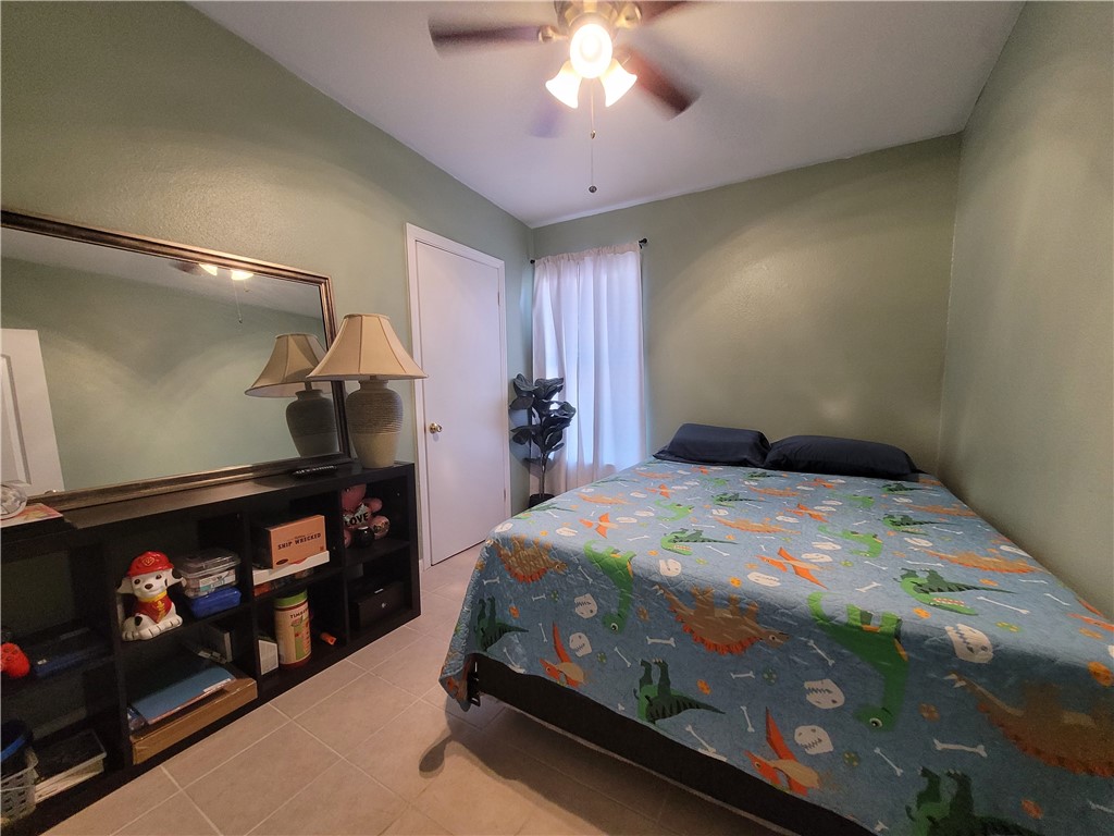 4902 Marion Circle Corpus Christi, TX 78411 - Photo 17 of 27 a bedroom with a bed and a chandelier