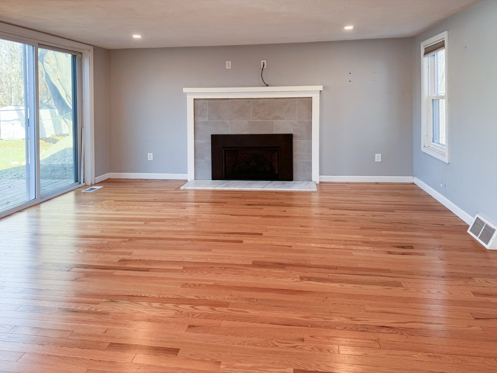 1 Chapel Lane Wareham, MA 02538 - Photo 12 of 29 an empty room with wooden floor fireplace and windows