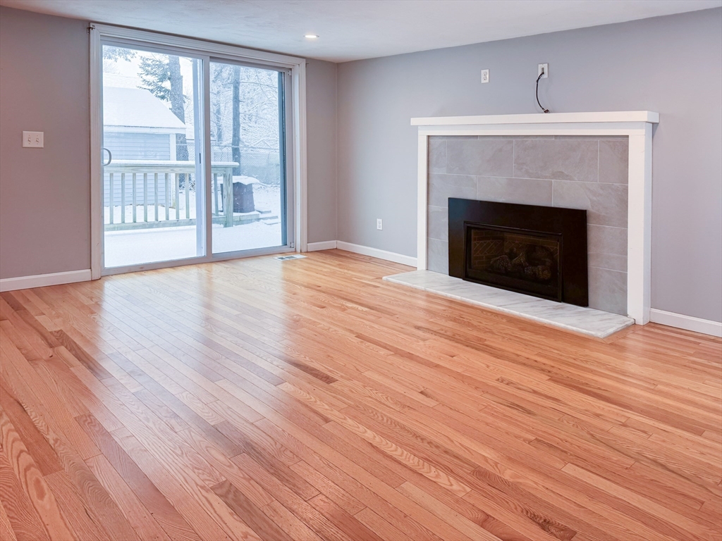 1 Chapel Lane Wareham, MA 02538 - Photo 13 of 29 a view of empty room with wooden floor and fireplace