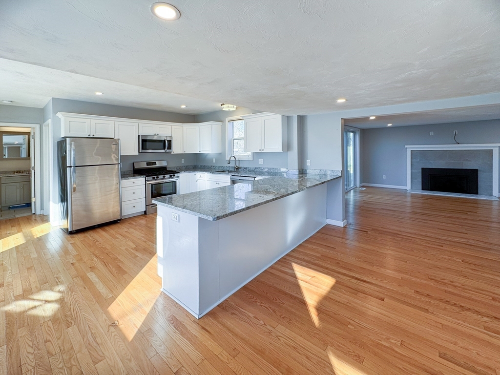 1 Chapel Lane Wareham, MA 02538 - Photo 6 of 29 a kitchen with stainless steel appliances granite countertop a refrigerator a sink dishwasher a stove and a wooden floors