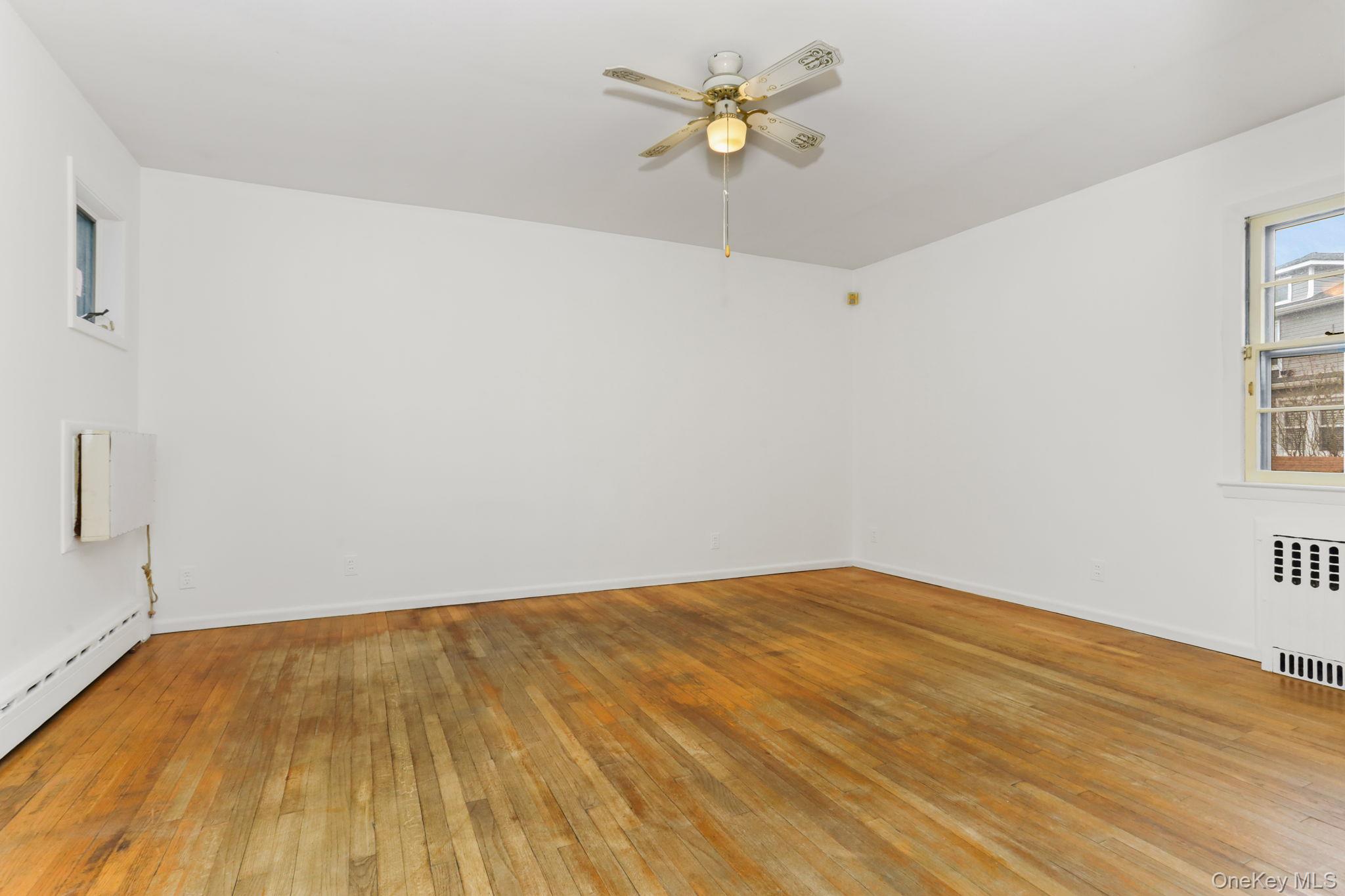 3 Hill Street New Rochelle, NY 10801 - Photo 19 of 46 a view of empty room with wooden floor and fan