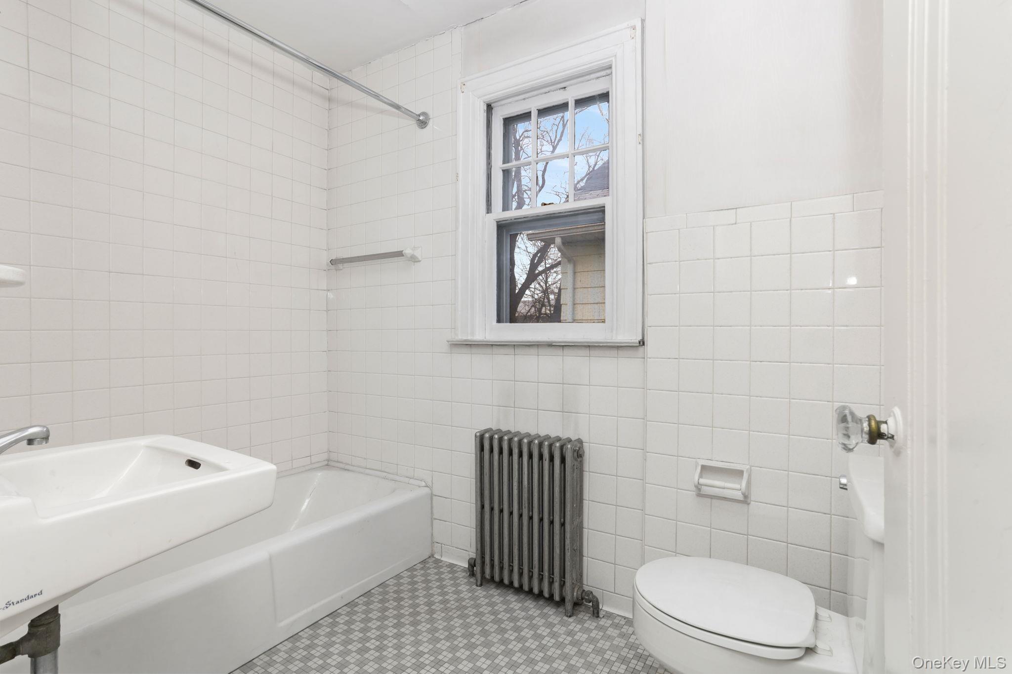 3 Hill Street New Rochelle, NY 10801 - Photo 24 of 46 a bathroom with a toilet a sink a shower and bathtub