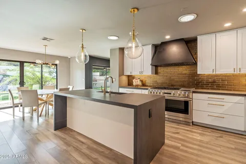 a kitchen with granite countertop a sink cabinets and stainless steel appliances