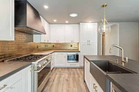 a kitchen with stainless steel appliances a stove and a wooden floor