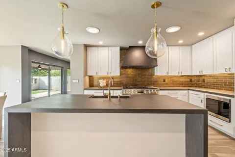 a kitchen with a dining table chairs stainless steel appliances and cabinets