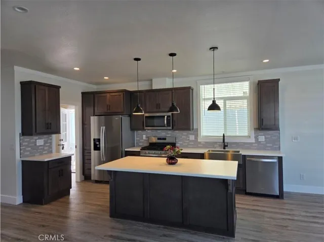a kitchen with kitchen island a sink stainless steel appliances and cabinets