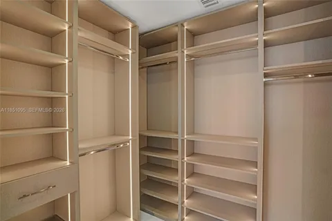 a view of walk in closet with empty racks