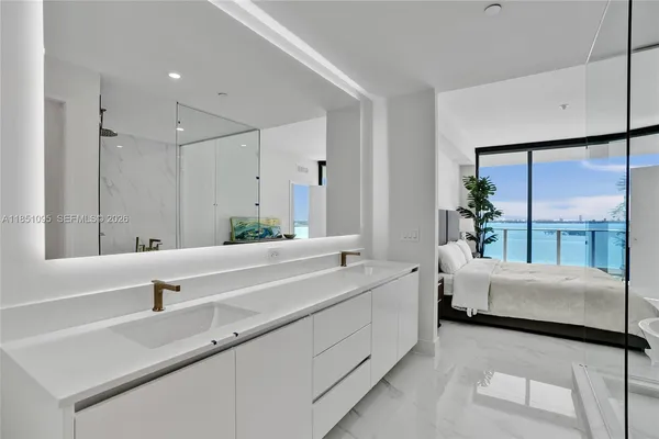 a en suite bathroom with a double vanity sink and large mirror