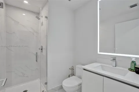a bathroom with a sink toilet vanity and shower