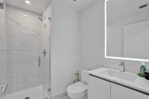 a bathroom with a sink toilet vanity and shower