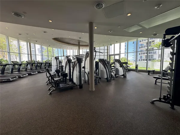 a view of a room with gym equipment and large mirror
