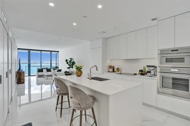 a kitchen with a stove a sink white cabinets and stainless steel appliances