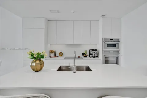 a kitchen with a refrigerator and white cabinets