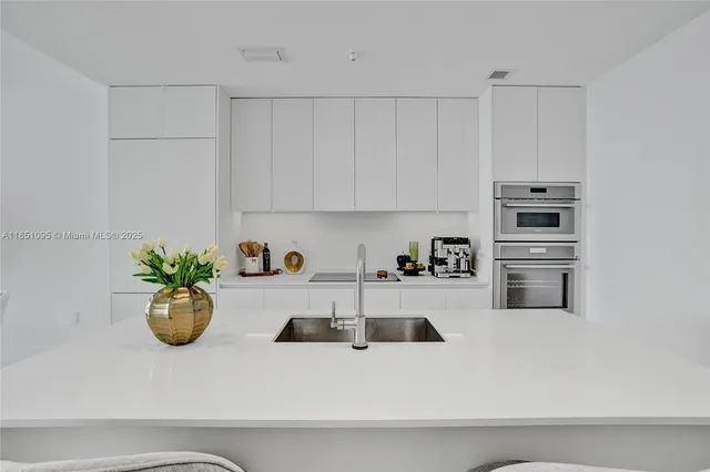 a kitchen with a refrigerator and white cabinets
