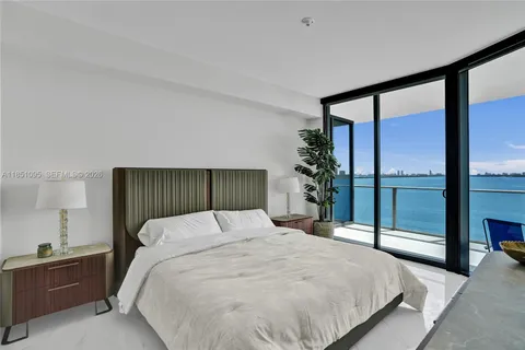 a bedroom with a large bed and a balcony view