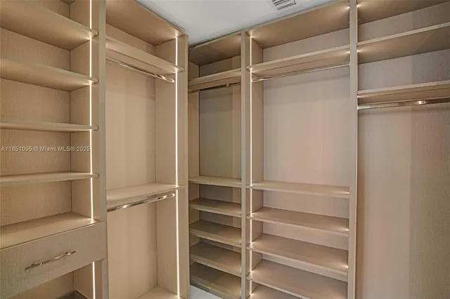 a view of walk in closet with empty racks