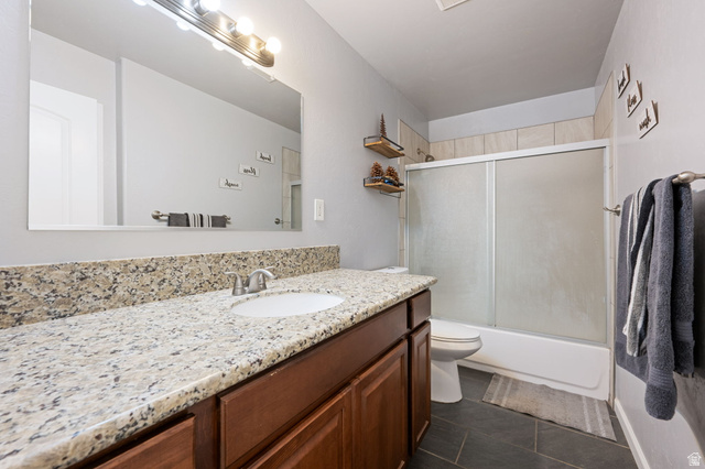 348 North Lodge Road Central, UT 84722 - Photo 10 of 25 Bathroom featuring vanity, shower / bath combination with glass door, and dark tile patterned floors