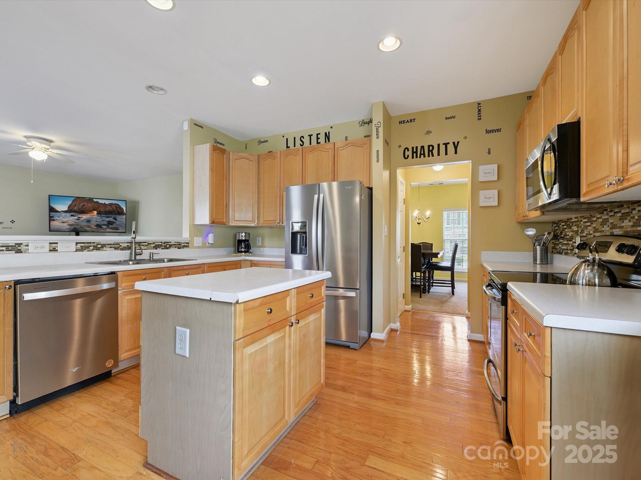 4959 Prosperity Ridge Road Charlotte, NC 28269 - Photo 11 of 40 a kitchen with stainless steel appliances granite countertop a refrigerator a sink dishwasher a stove with wooden cabinets and floor