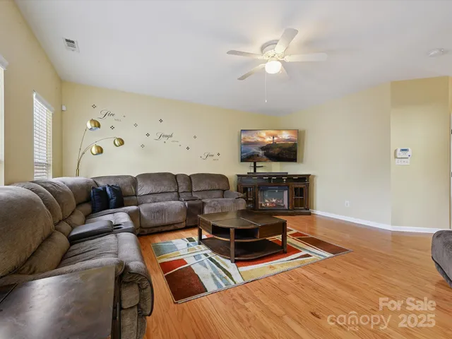 a living room with furniture and a flat screen tv with wooden floor