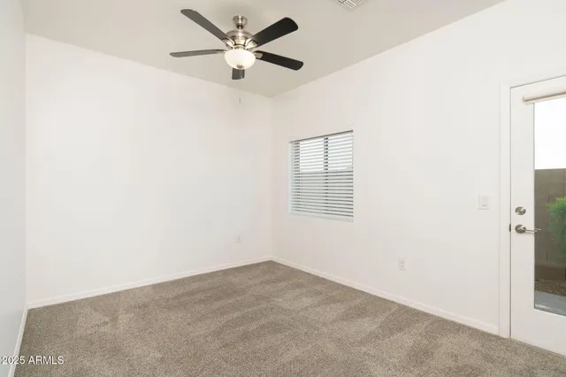 an empty room with a window and a fan