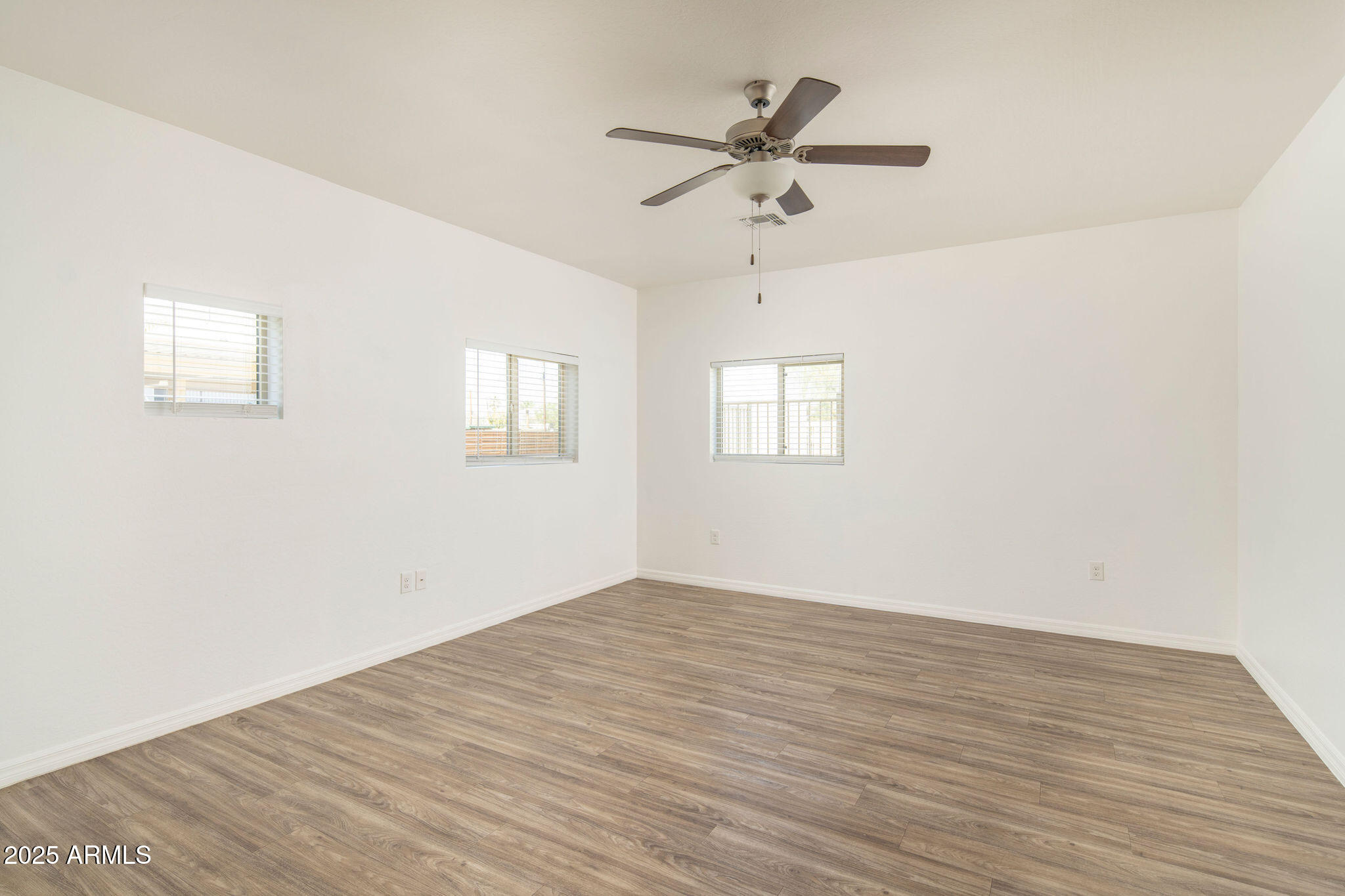 2016 West Orangewood Avenue Phoenix, AZ 85021 - Photo 21 of 22 an empty room with wooden floor fan and windows