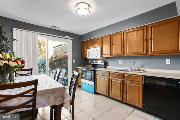 a kitchen with a table chairs sink and cabinets