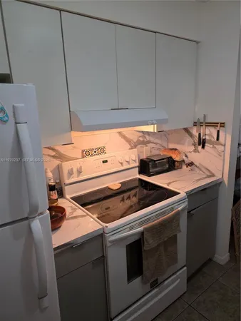 a stove top oven sitting inside of a kitchen