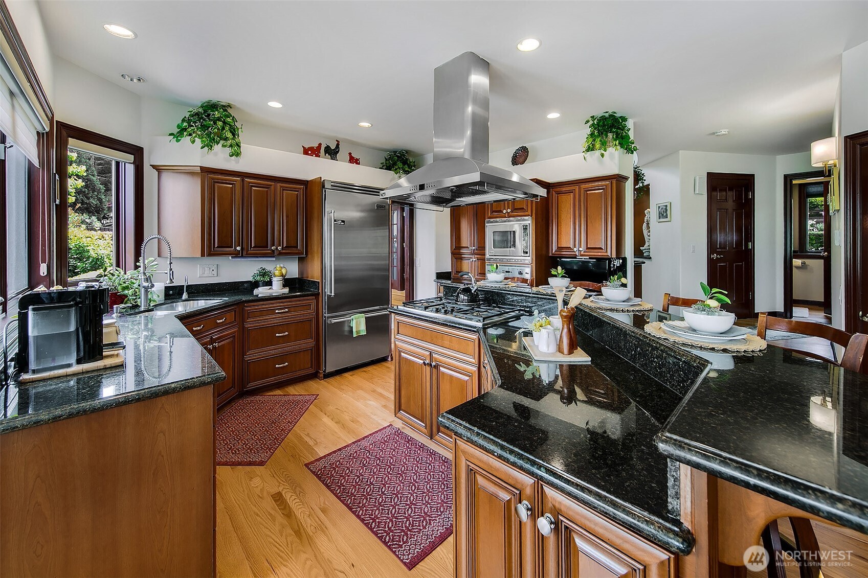21031 49th Avenue Southeast Bothell, WA 98021 - Photo 11 of 40 a kitchen with stainless steel appliances granite countertop a stove a sink dishwasher a microwave oven and a dining table with wooden floor