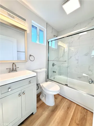 a bathroom with a shower sink vanity mirror and toilet