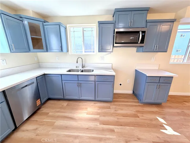 a kitchen with stainless steel appliances a stove a sink and a microwave