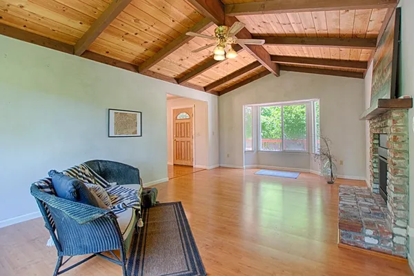 a view of a livingroom with furniture wooden floor windows and a fireplace