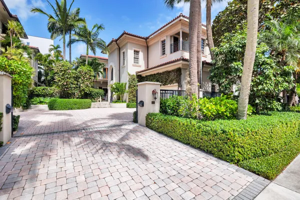 a front view of a house with a yard and potted plants