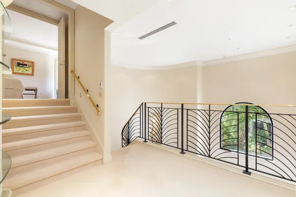 a view of staircase with lots of frames on wall and a large window