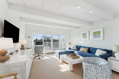 a living room with furniture a flat screen tv and a large window