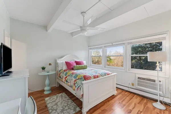 a bedroom with a bed and a flat tv screen on dresser