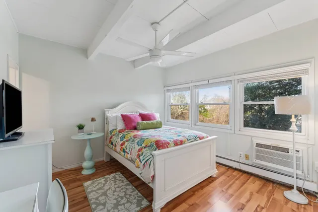 a bedroom with a bed and a flat tv screen on dresser