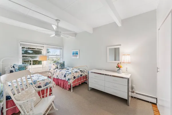 a bedroom with two beds and windows