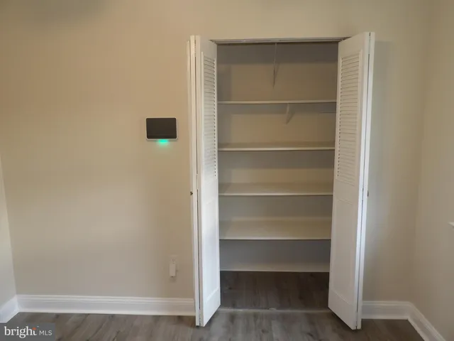 a view of walk in closet with empty racks