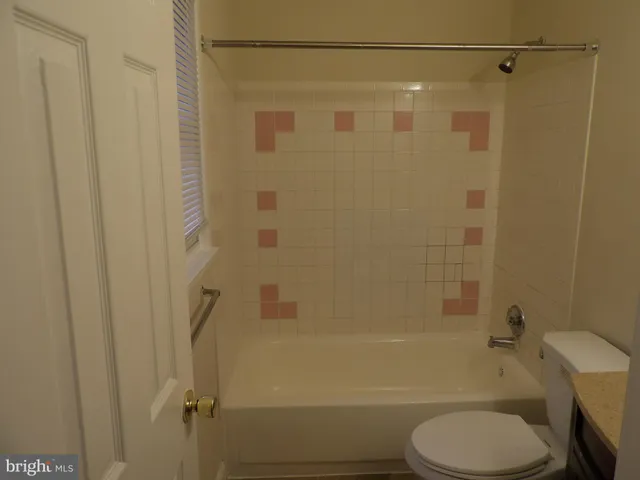 a bathroom with a shower a toilet and a bath tub