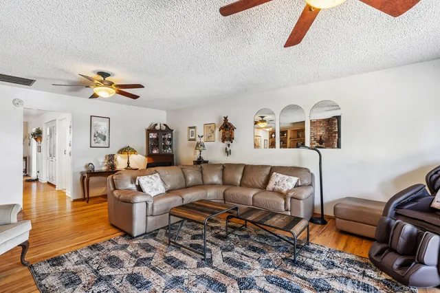 a living room with furniture ceiling fan and a rug