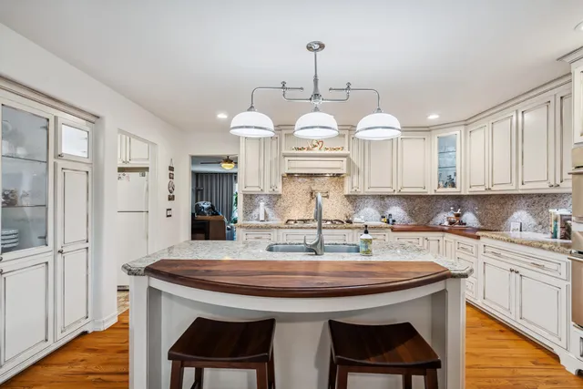 a kitchen with stainless steel appliances granite countertop a kitchen island a stove a table and chairs in it