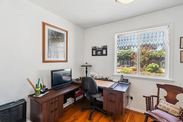 a view of a workspace with furniture and a window