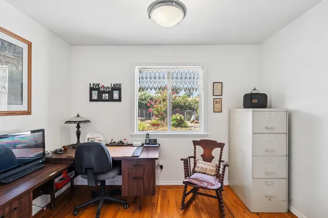 a view of a workspace with furniture and a window