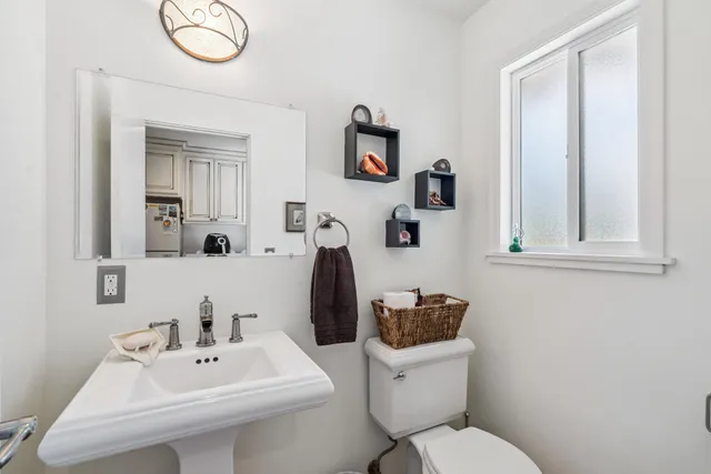 a bathroom with a sink a toilet and mirror