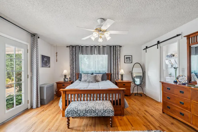a bedroom with a bed a chandelier and dresser