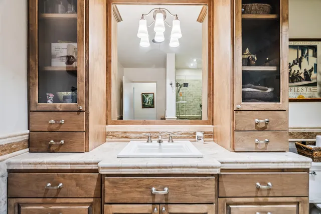 a sink with a mirror and cabinets